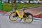 An electric Bicycle stands on a city street. Yellow electric bike in the city