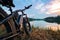 Electric bike with thick wheels on the background of lake and sunset. Sports fatbike. Picturesque place in the village. The