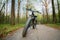 Electric bike with thick wheels on a road in the forest. Healthy sports hobby. Black fatbike