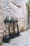 Electric black fans stand against a stone wall in a European city. Cooling devices on the street of the city