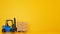 Electric blue forklift loads a wooden pallet with boxes on yellow background