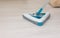 Electric broom on a background of light laminate. Clean floor. Disinfection. Concept cleaning company. Space for text