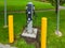 Electric car charging point installed on green lawn with yellow pillars around