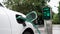 Electric car plugged in with charging station in eco green park. Peruse