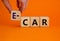 Electric car symbol. Businesman hand holds wooden cubes with the word `E-car, electric car`. Beautiful orange background, copy