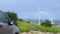 Electric car, wind turbines rotating, green energy source, clean environment