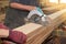 Electric circular saw is being cut a wood board by workers in woodwork shop.