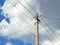 Electric concrete pillar against a blue sky. Illustration on the theme of electricity supply and rising prices. The wires cross