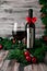 Electric corkscrew in steel gray. Near a glass and a bottle of wine. The bottle is decorated with a red bow. Gray wooden