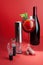 Electric corkscrew, vacuum stopper and wine aerator. On a red background. Next to it is a glass of sangria and a bottle of wine