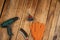 Electric drill, knot cup wire brush, metal brush and orange gloves. Hand and power tools lie on the boards. Woodworking. Top view