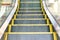 Electric Escalator. Close up - floor platform - yellow bands. gray metal steel line. Way up
