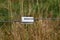 Electric fence gate protects a green grass pasture