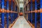 Electric forklift between large shelving in a modern storage building.