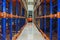 Electric forklift between large shelving in a modern storage building.