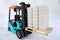Electric forklift with plastic containers on the snow