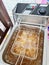 The electric fryer is being used to fry food