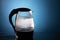 Electric glass kettle on blue background