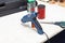 Electric glue gun for squeezing blue glue on the workbench for needlework in the workshop next to scissors and weighting agent for