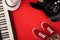 Electric guitar, synthesiser and red stylish sneakers, on red background