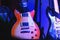 Electric guitars stand on stage on stands under light of spotlights