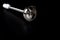 Electric hand blender nozzle with sharp blade isolated on the dark surface background