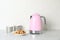 Electric kettle, cups and cookies on counter in kitchen