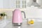 Electric kettle, cups and lemons on table in kitchen