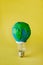 Electric lamp decorated as plasticine Earth model on yellow back