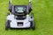 Electric lawn mower on a green grass, nature background
