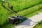 Electric lawn mower Makita on a green lawn. Difference between trimmed and uncut grass. Abakan, Russia - June 12, 2020