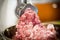 An electric meat grinder twists the meat