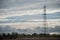 Electric metallic pylon on cloudy sky background