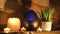 Electric oil diffuser lamp, candles on wooden table in room