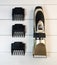 Electric pet clipper with plastic nozzles and ceramic knife on a light wooden background