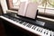 Electric piano with empty sheet music by the window, right side view.