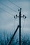 Electric pillar with wires in dark blue overcast sky