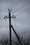 Electric pillar with wires in dark overcast sky