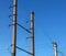 Electric pole with a linear wire against the blue sky close-up. Power electric pole