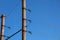 Electric pole with a linear wire against the blue sky close-up. Power electric pole