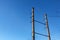 Electric pole with a linear wire against the blue sky close-up. Power electric pole