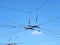 Electric power grid view as a part of city trolleybus system against blue sky.