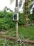 Electric power meter box fixed to the pole with DANGER signboard written in Malay word `BAHAYA` at the farm entrance
