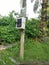 Electric power meter box fixed to the pole with DANGER signboard written in Malay word `BAHAYA` at the farm entrance