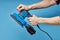 Electric sanding machine for home handyman use, on blue background