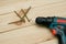 Electric screwdriver on a wooden table. Side view of the black metallic screws, electric screwdriwer on the wodden boards