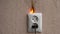 Electric socket fire. On fire electric wire plug peceptacle on the concrete wall exposed concrete background