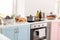 Electric stove with stewpan and products on table in modern kitchen