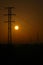 Electric supply main at foggy sunrise