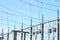 Electric transformers are suspended on concrete poles against the sky